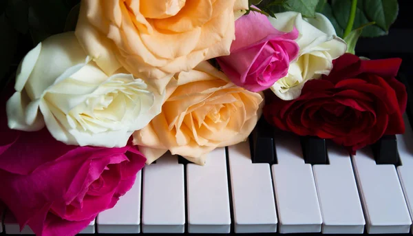 Bouquet di rose colorate al pianoforte. Fiori su uno strumento musicale. Biglietto d'auguri. Festa internazionale della donna, festa della mamma, romanticismo, amore, fiori — Foto Stock