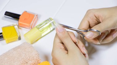 Manicure. Cut your fingernails with small nail scissors. Trim your nails. Young woman taking care of her nails. Hygiene, clipping, cutter, self, skincare, procedure, routine, treatment. clipart