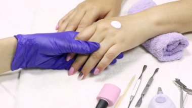 Manikürcü, müşterinin eline nemlendirici sürüyor. SPA manikür, prosedür, nemlendirici. El losyonu, krem. Cilt bakımı. Güzellik salonu. Manikür konsepti. Güzel tırnaklar. Yumuşak ten. Kozmetik kremi