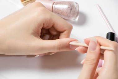 Manikür. Tırnak derisini tahta bir sopayla geriye it. Bir kadın kendi manikürünü kendisi yapar. Evde tırnak bakımı. Güzellik sağlık spa tedavisi konsepti. Cilt bakımı, hijyen. Manikürden önce çiviler hazırlanıyor.