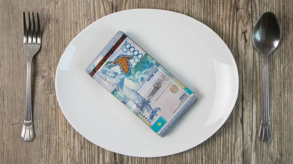 Kazakistan 'ın büyük bir kısmı beyaz bir tabakta. Kazakistan' ın ulusal para birimi. Kiralık alarm. Market sepeti, bütçe tasarrufları.