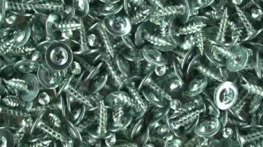 Metalik doku arka planı. Vidalar ve dişliler. Tamir ve onarım için aletler. Sürgülerin arka planı. Paslanmaz çelik cıvatalar. Galvanize metal bağlayıcılar. Kapatın. Yukarıdan görünüşü.
