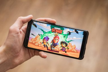 hand holding phone with brawl stars mobile game clipart