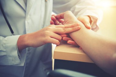 Doktor hastanın nabzını kontrol ediyor