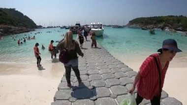 Phuket, Tayland - 27 Mart 2018: sürat teknesi Patok Bay, Koh Racha Yai ada, gri duba köprü üzerinde yürüme turist