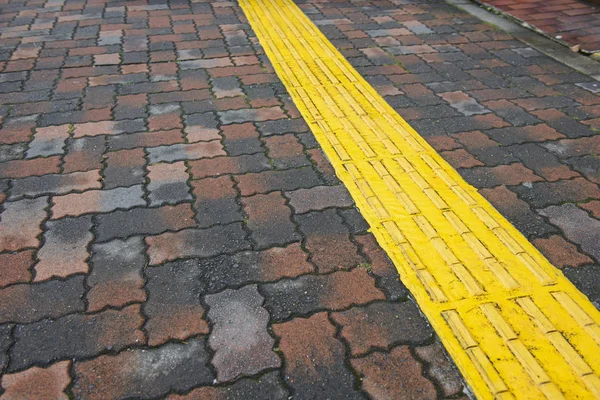 視覚障害者のための歩道ガイド 盲目の人々 のための歩道に黄色のコンクリート玉石 — ストック写真