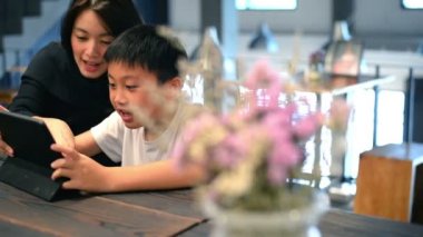 Anne ve oğlu dijital tablet birlikte café'de kullanma