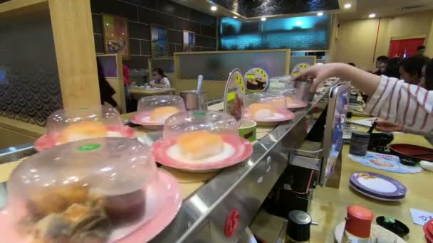 クアラルンプール マレーシア 2018 料理の寿司や刺身寿司王レストランでコンベア ベルト上を転がる — ストック動画