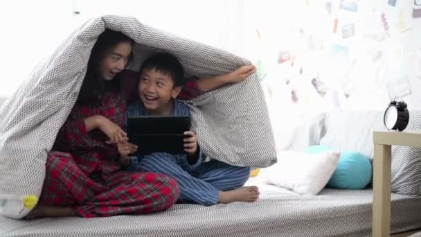 母亲和她的儿子一起看电影在毯子下的平板电脑 — 图库视频影像