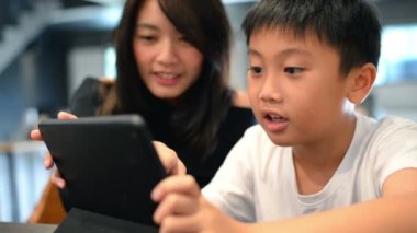 Asyalı çocuk ve annesi dijital tablet birlikte kullanma