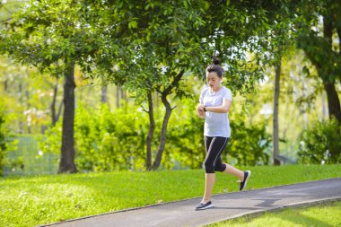 Genç kadın akıllı izlemek için arıyorum bir parkta koşu