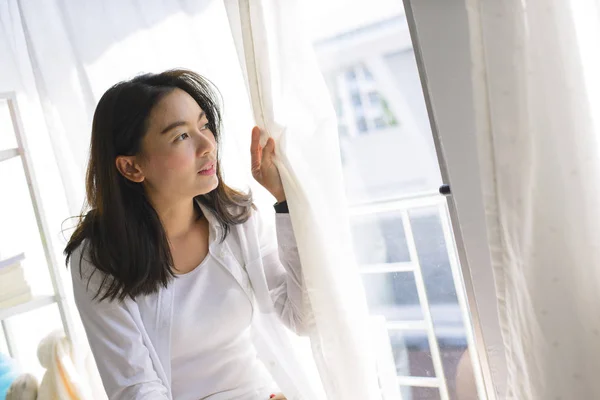 Oturma Pencere Perdeleri Açmayı Yalnız Asyalı Kadın - Stok İmaj