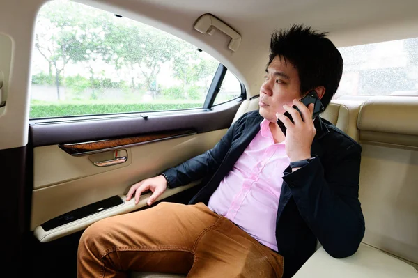Asiatisk Man Pratar Mobiltelefon Och Tittar Igenom Dokument Medan Sitter — Stockfoto