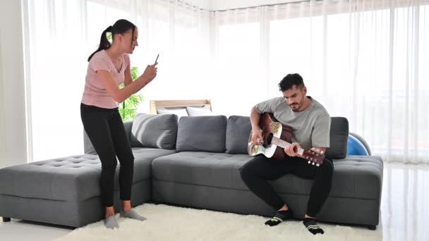 Young Couple Faz Vídeo Seu Namorado Tocando Uma Guitarra Acústica — Vídeo de Stock