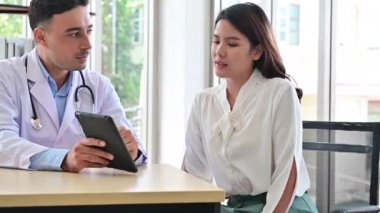 4K Genç kadın hastanedeki sağlık kontrolünde doktora yardım ediyor.