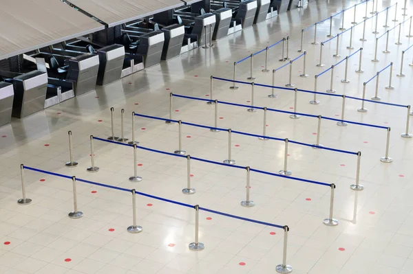 Kalabalık kontrol engelleri olan boş havaalanı terminali salonu