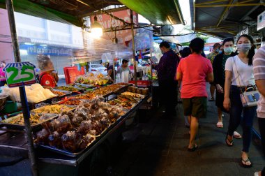 Bangkok, Tayland - 23 Haziran 2020: Taylandlılar sokak yemeği alırken cerrahi maske takarlar