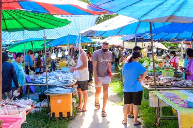 Phuket, Tayland - 20 Temmuz 2020: Covid-19 karantinası sırasında Phuket 'teki bit pazarında yürüyen turistler