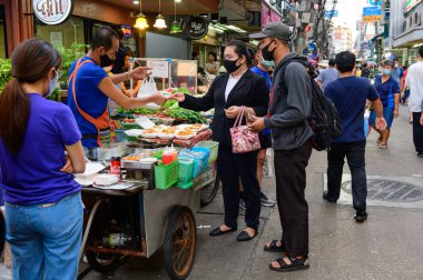 Bangkok, Tayland - 5 Ağustos 2020: Tanımlanamayan sokak satıcısı müşteriler için köpük bir kutuda yiyecek satıyor