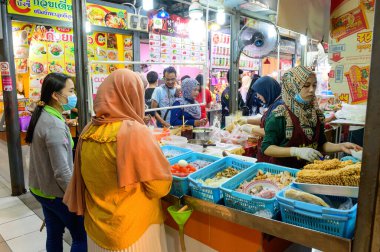 Hat Yai, Tayland - 6 Ağustos 2020: Taylandlılar Muslim satıcılarından yemek alırken cerrahi maske takarlar