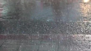 Sokak ışıkları ve renkli trafik ışıklarıyla yavaş yağmur damlası