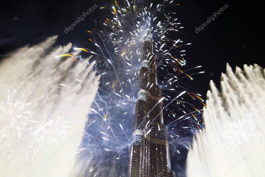 Festive firework in Dubai. Beautiful colorful holiday fireworks in the evening sky with majestic clouds, long exposure