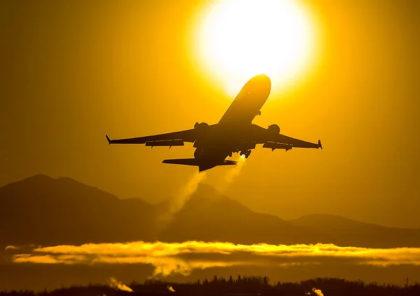 Arka plan bir gün batımının yolcu uçağa kalkış. Hava gemisi günbatımında uçuş.
