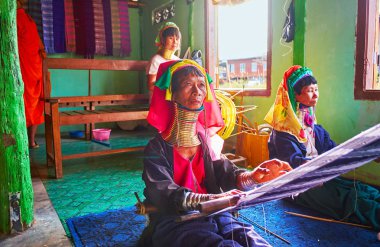 Inle Gölü, Myanmar - 18 Şubat 2018: Padaung Kayan kabilesinin uzun boyunlu kadınlar onların geleneksel Tekstil Atölyesi ziyaret edin ve bazı Hatıra Eşyası veya pamuklu eşarp, el tezgahı üzerinde 18 Şubat Inle Gölü üzerinde yapılan satın turist çekmek.