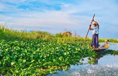 Inle Gölü, Myanmar - 18 Şubat 2018: Köylü yüzen su üzerinde 18 Şubat Inle Gölü üzerinde onun kayık kenarında duran, çiftlikte boyunca.