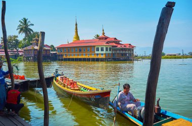 Ywama, Myanmar - 18 Şubat 2018: Budist manastır kayaks Inle Gölü, Limanında demirleme üzerinde 18 Şubat Ywama için eski ahşap direklerin üzerinden görünümü.