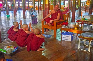 Inle Gölü, Myanmar - 18 Şubat 2018: Bhikkhu (keşiş) boys - samaneras (acemi rahipler) konuşan ve onlara kırmızı elbiseler, üzerinde 18 Şubat Inle Gölü içinde cats, atlama Nga Phe Kyaung Manastırı verir