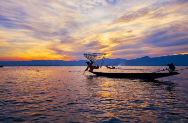 Intha, Myanmar - 18 Şubat 2018: Yerel balıkçı kayık kenarında kalan ve yeteneklerini konik net, 18 Şubat Intha olarak gösteren bir görünüm ile Inle Gölü günbatımı.
