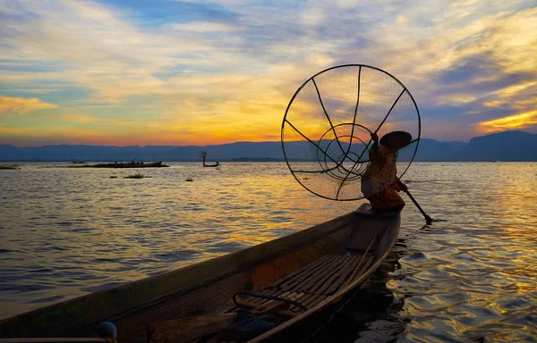 Bir bacak Inle Gölü, Myanmar akşam karanlık sular arasında kürek çekmeye alışılmadık tekniği gösteren Kano, Birmanya balıkçı karanlık siluet.