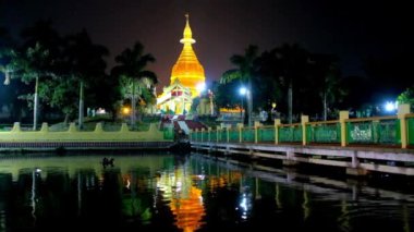 Akşam yürümek Mahavijaya Pagoda gölet manzaralı bahçe, altın stupa üzerinde ve onun yansıması siyah sularda, Yangon, Myanmar.