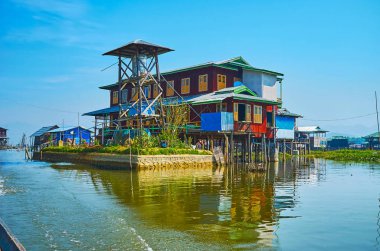 İlkel ahşap su kulesi köyü Inle Gölü, Inpawkhon, Myanmar üzerinde stilts büyük evin yanındaki.