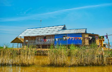 Sazlık Inle Gölü, Ywama, Myanmar çalılık arkasında giysi kurutma ile eski köylülerin evi.