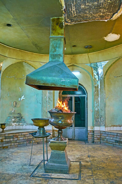 КЕРМАН, ИРАН - 16 октября 2017 года: Молитвенный зал Зороастрийского храма огня, священный огонь - Атар горит в вазе в середине, 16 октября в Кермане
.