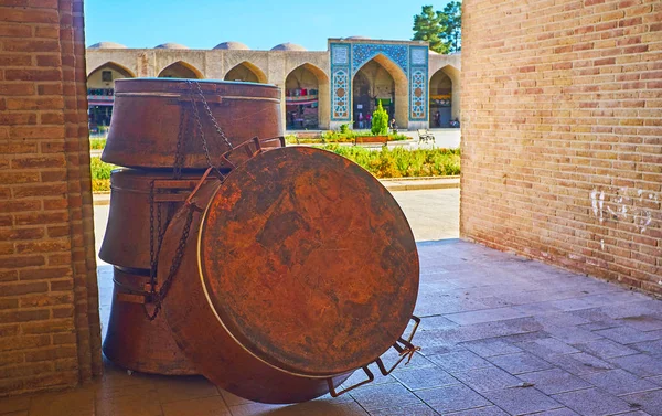 The large copper pans attract people to visit stores and workshops of coppersmiths\' alley of Ganjali Khan Bazaar, Kerman, Iran.