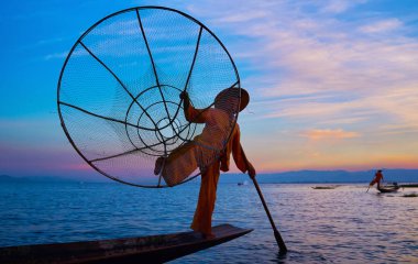 Intha, Myanmar - 18 Şubat 2018: kürek çekmeye bir bacak ziyaret kartı yerel balıkçıların, onlar sık sık yapar Sihirli zevk için seyahat günbatımı Inle Gölü üzerinde 18 Şubat Intha içinde turistler, eğlendirmek.