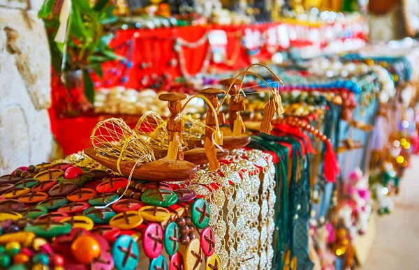 The small wooden souvenirs of local one-legged fishermen with tiny fish on the rod and conical net in canoe, Inn Thein market, Inle Lake, Myanmar.