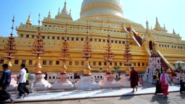 Bagan, Myanmar - 25 Şubat 2018: Turist ve Budist üzerinde 25 Şubat Bagan, altın çiçek ve çan, oyma Kulesi ile dekore Shwezigon Pagoda ana stupa boyunca yürümek hacılar