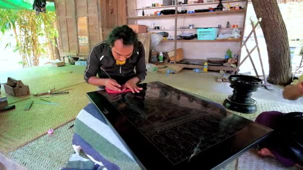 バガンで 日漆器工房のパビリオンに座っているエッチング針でスクラッチの漆パネルの画像が職人で作成バガン ミャンマー 2018 — ストック動画