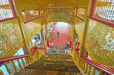 YWAMA, MYANMAR - FEBRUARY 18, 2018: The covered staircase of Hpaung Daw U Pagoda on Inle Lake is decorated with golden mirror patterns, shining on day light, on February 18 in Ywama.