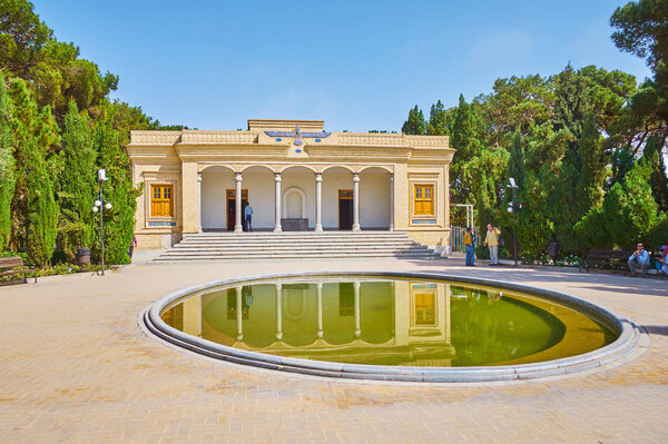 ЯЗД, ИРАН - 18 октября 2017 года: Фасад Зороастрийского храма Аташ Бехрам (Победоносный огонь) с пышным зеленым садом вокруг него и маленьким прудом, 18 октября в Язде
.