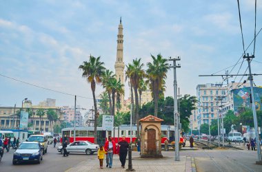 Alexandria, Mısır - 18 Aralık 2017: Meşgul Mahta Al Raml kaotik trafik, tramvay terminal ve uzun boylu minare el Qaed Ibrahim Camii arkasında bulunan küçük Parkı, 18 Aralık İskenderiye ile kare.