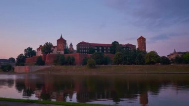 Mor günbatımı pitoresk Wawel Castle üzerinde Vistula Nehri, Krakow, Polonya sakin sularına yansıyan.
