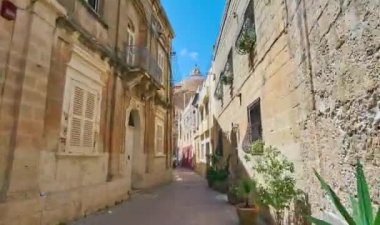 Mosta, Malta - 14 Haziran 2018: Old Town varsayım, bombeli veya Rotunda, da ünlü üzerinde Haziran 14 Mosta Parish Kilisesi ile dar backstreet için merkezi kare boyunca yürüyüş.