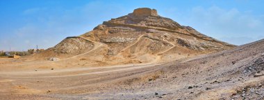 Panorama of the desert rocky hills of Dakhma archaeological site with  ancient Zoroastrian burial Tower of Silence on the top, Yazd, Iran.