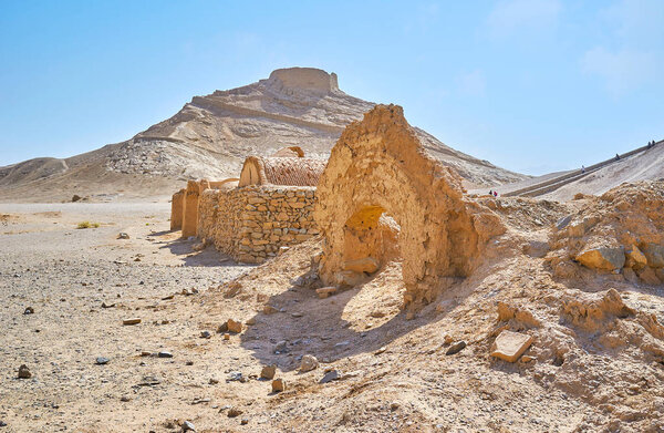Остатки церемониальных зданий Хайеле и захоронение - Башня молчания, увенчанная скалистым холмом на заднем плане, Язд, Иран
.
