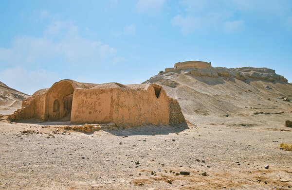 Сохранившиеся здания древнего зороастрийского захоронения - Башня молчания (Дахма) на вершине холма и церемониальный Хайеле на переднем плане, Язд, Иран
.